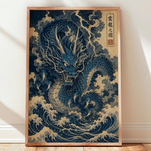 May include: A framed vertical wall art print featuring a detailed blue dragon emerging from turbulent ocean waves and swirling clouds. The artwork includes Japanese kanji text in a vertical rectangular box on the right side with a red seal stamp.