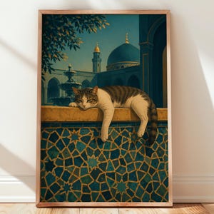 May include: A framed wall art print featuring a brown and white tabby cat resting on a ledge. Below the cat is a wall with a blue and gold geometric tile pattern. In the background, a fountain and a mosque with a blue dome are visible.
