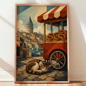 May include: A framed art print depicting a street scene with a red food cart filled with brown ring-shaped breads. A tabby cat sleeps on the cobblestone ground near the cart. In the background, a stone tower rises above a city by the water.