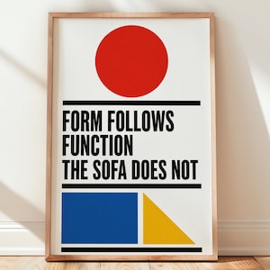 May include: A rectangular framed wall art print featuring a white background with a large red circle at the top, black horizontal lines, and the text "FORM FOLLOWS FUNCTION THE SOFA DOES NOT" in black. A blue rectangle and a yellow triangle are at the bottom.