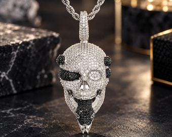 May include: A silver-toned skull pendant necklace featuring a rope chain. The skull is encrusted with clear white stones and accented with black stones around the eye, side, and a snake-like figure emerging from the jaw, all set in metal.