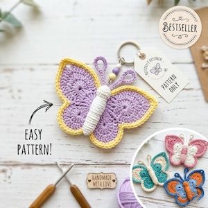 May include: A crochet butterfly keychain with lavender wings and a yellow border, featuring a white body, a metal ring, and two small beads. A white tag reads BUTTERFLY KEYCHAIN PATTERN ONLY. A circular badge says BESTSELLER and text reads EASY PATTERN.