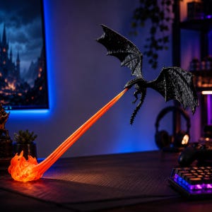 May include: A black dragon figurine in flight with large, textured wings, emitting a long, translucent orange stream of fire that connects to a glowing, swirling orange flame base on the surface, creating a dynamic display of a fire-breathing creature.