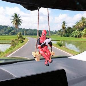 Divertido adorno colgante de Deadpool para el espejo retrovisor del coche, con múltiples poses de acción y detalles al estilo cómic.