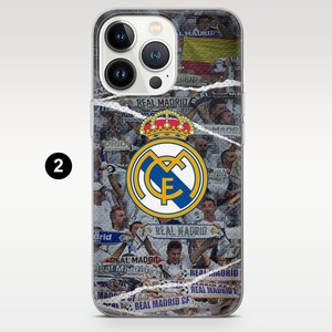 May include: A clear smartphone case featuring a collage of Real Madrid soccer fans and scarves with the text Real Madrid. The center displays the official Real Madrid crest in blue, gold, and white, topped with a crown, over a white background.