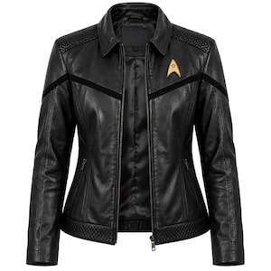 Può includere: Una giacca in pelle nera con chiusura frontale a zip, colletto classico e pannelli trapuntati su spalle e orlo. Un'insegna delta Starfleet color oro è fissata sul petto sinistro, con inserti in similpelle scamosciata nera che attraversano il petto.