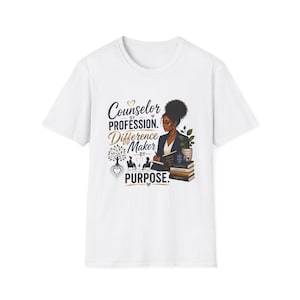 Op de afbeelding: Een wit T-shirt met korte mouwen en een afbeelding van een counselor, boeken en een boom. De tekst luidt: Counselor BY PROFESSION. Difference MAKER BY PURPOSE. Het ontwerp bevat een kleine plant in een pot en twee silhouetten.