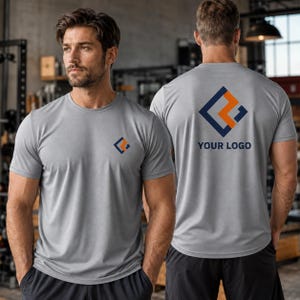 Könnte beinhalten: Ein hellgraues kurzärmeliges T-Shirt mit einem kleinen geometrischen Logo auf der linken Brust und einer größeren Version desselben Logos auf der Rückseite, unter der der Text YOUR LOGO in einer dunkelblauen serifenlosen Schrift gedruckt ist.