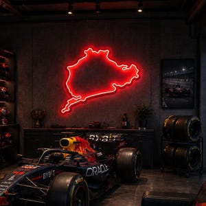 以下が含まれることがあります： OracleとRed Bullのロゴが入ったF1レースカー、壁に輝く赤いネオンのサーキット図、トロフィーとヘルメットが並ぶ棚、黒いレザーソファ、Monzaのコース図が載った本が置かれたテーブルがある暗いガレージ空間。