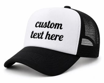 May include: A black and white trucker cap featuring a solid white front panel with the black embroidered text custom text here, a black curved peak, and a black mesh back panel with an adjustable snapback closure for a structured fit.