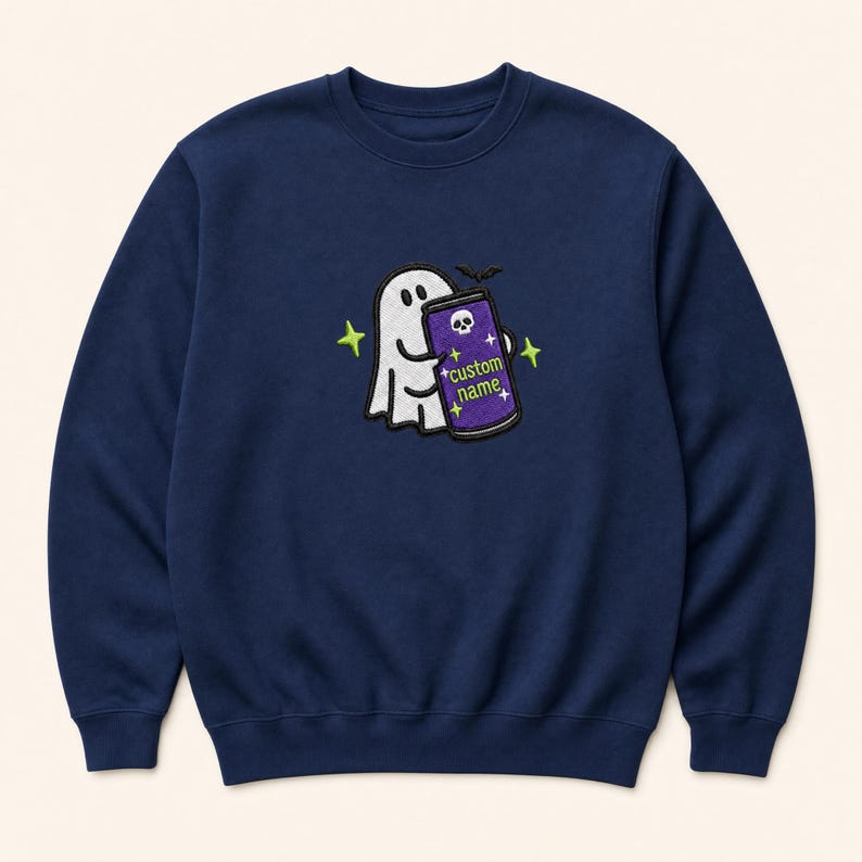 May include: A navy blue crewneck sweatshirt featuring an embroidered design of a white ghost holding a purple can. The can displays a white skull icon and the text custom name in lime green, surrounded by small lime green star accents.