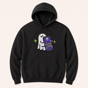 May include: A black hooded sweatshirt featuring an embroidered graphic of a white ghost holding a purple can. The can displays a white skull icon, small star shapes, and the text custom name in green. The design includes small green star accents.