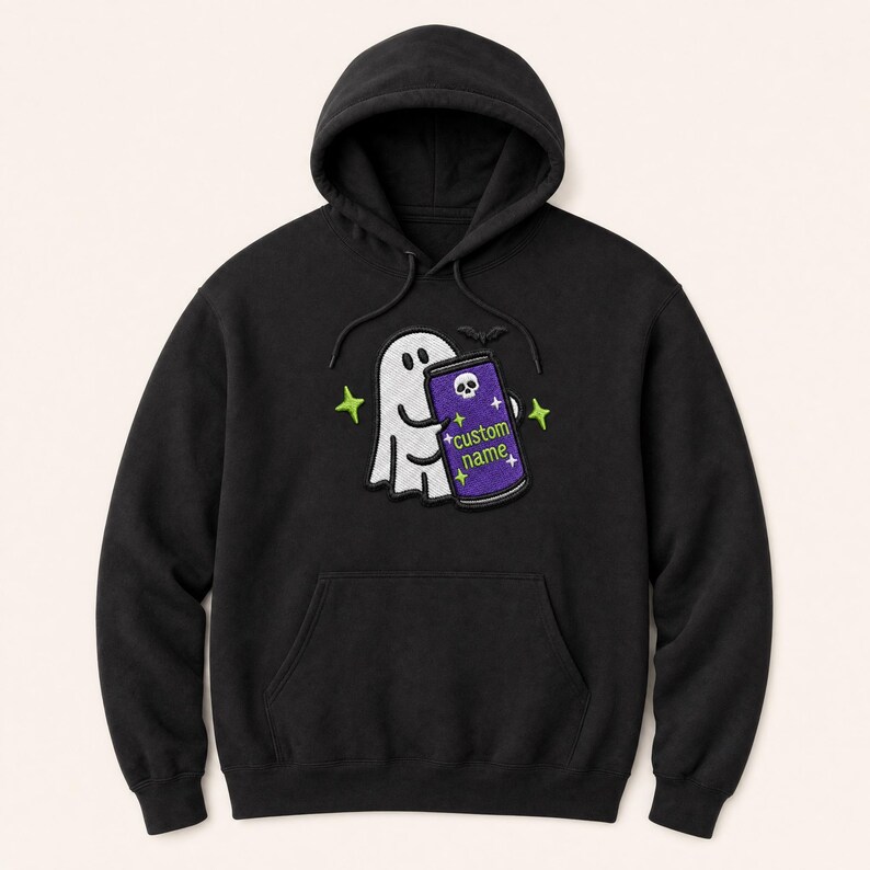 May include: A black hooded sweatshirt featuring an embroidered graphic of a white ghost holding a purple can. The can displays a white skull icon, small star shapes, and the text custom name in green. The design includes small green star accents.