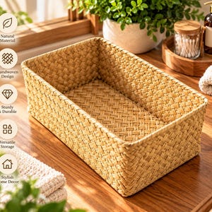 May include: A rectangular storage basket featuring a light tan woven pattern. The basket has a structured, open-top design with a consistent braided texture throughout the sides and base, providing a functional container for organizing various household items.