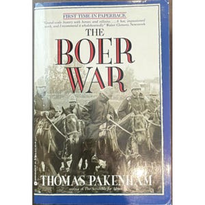 Pode incluir: Um livro de bolso intitulado The Boer War de Thomas Pakenham. A capa apresenta uma fotografia histórica a preto e branco de soldados a cavalo usando capacetes coloniais. O título está impresso em letras serifadas grandes pretas e vermelhas.