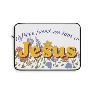 Puede incluir: Una funda rectangular para portátil con fondo blanco que presenta el texto azul What a friend we have in y el texto grande amarillo Jesus. El diseño incluye una colorida ilustración de varias flores silvestres en tonos rosa, azul y amarillo.