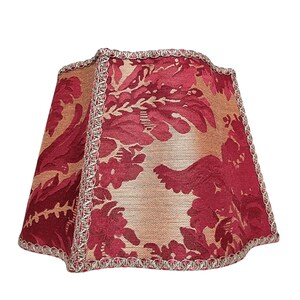 Puede incluir: Una pantalla de l&aacute;mpara roja y dorada con un patr&oacute;n floral y un ribete plateado.