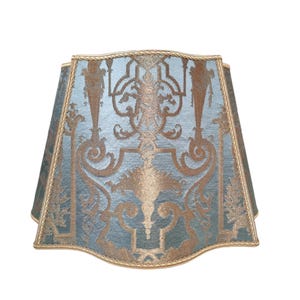 May include: A blue and gold lampshade with a decorative pattern. The lampshade is made of fabric and has a scalloped edge.