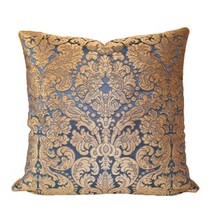May include: A blue and gold decorative throw pillow with a damask pattern.