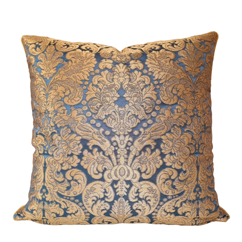 May include: A blue and gold decorative throw pillow with a damask pattern.