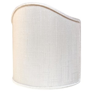 May include: A white fabric lampshade with a curved top and a textured surface.