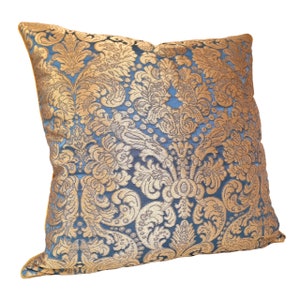 May include: A blue and gold decorative throw pillow with a damask pattern.