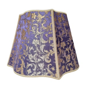 May include: A purple and gold lampshade with a floral pattern.