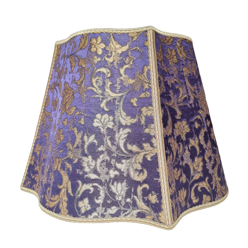 May include: A purple and gold lampshade with a floral pattern.