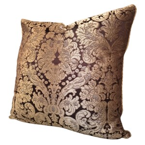 May include: A decorative throw pillow with a gold and brown damask pattern.