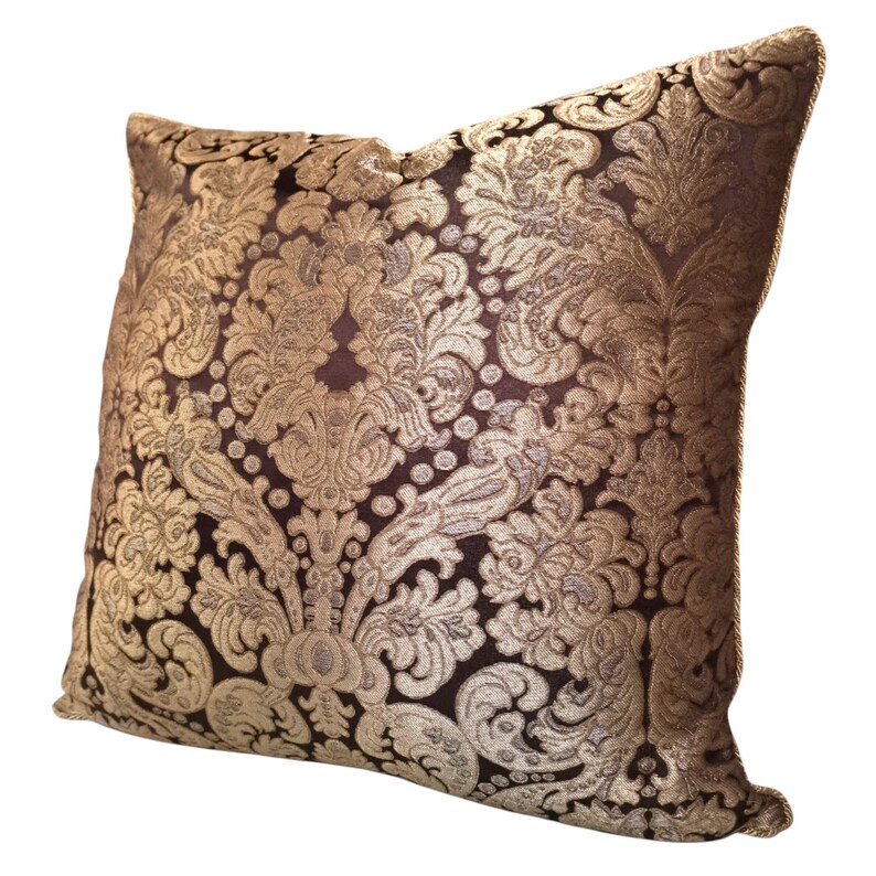 May include: A decorative throw pillow with a gold and brown damask pattern.