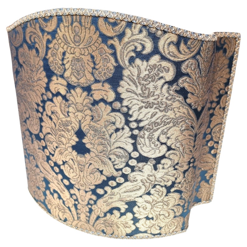 May include: A curved lampshade with a black background and a gold damask pattern.
