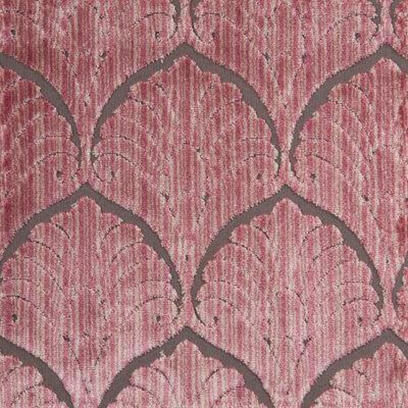 May include: A close-up of a pink fabric with a repeating pattern of stylized leaves. The fabric has a subtle sheen and a textured surface.