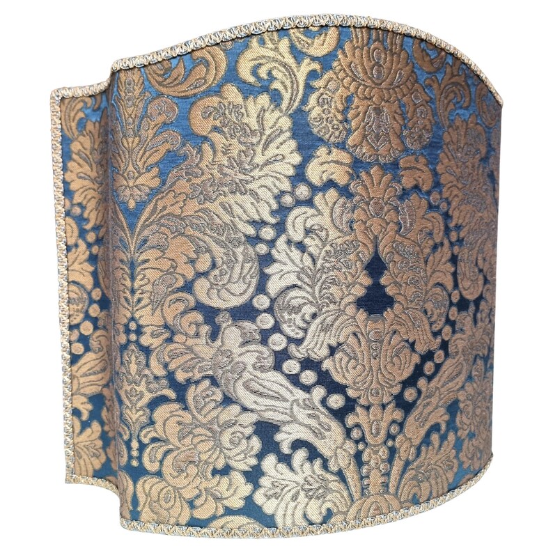 May include: A blue and gold patterned lampshade with a scalloped edge.