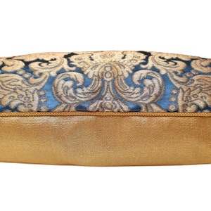 May include: A blue and gold patterned throw pillow with a gold trim. The pillow is made of a soft, luxurious fabric.