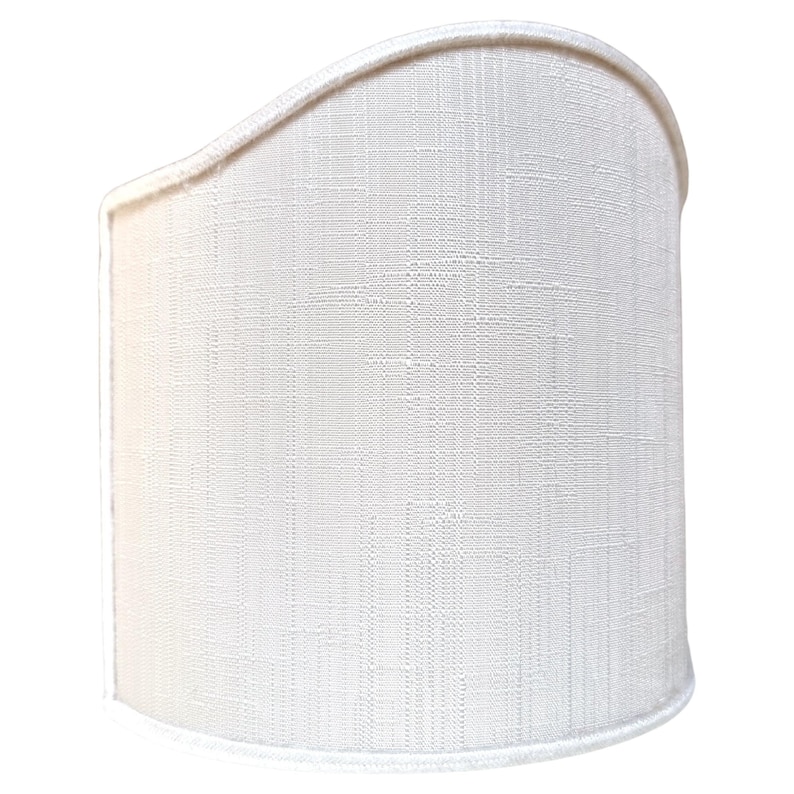 May include: A white fabric lampshade with a curved top and a textured surface.