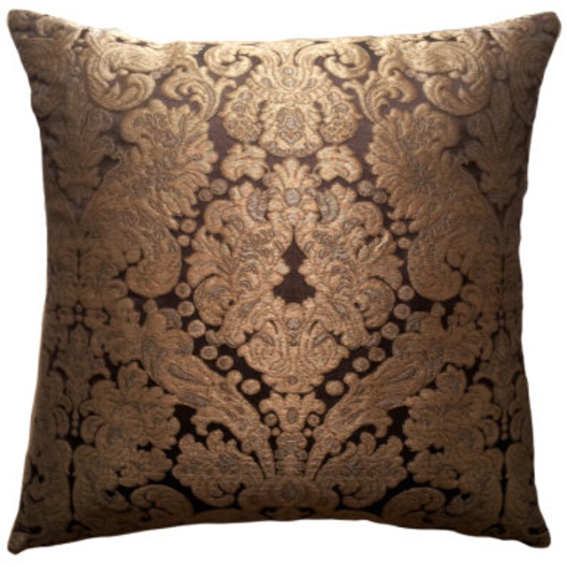 May include: A brown and gold decorative throw pillow with a damask pattern.