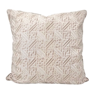 May include: A beige throw pillow with a geometric pattern. The pattern is made up of white lines that create a series of interlocking squares and triangles.