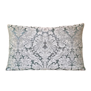 May include: A decorative throw pillow with a light blue background and a white damask pattern.
