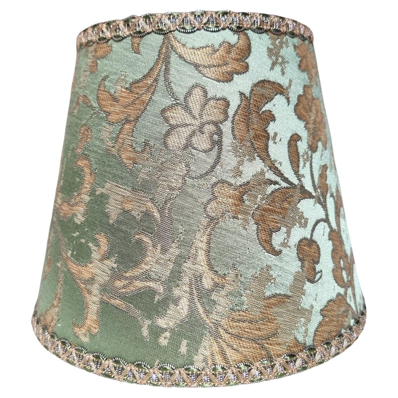 Pode incluir: Um abajur verde com um padr&atilde;o floral dourado e uma borda verde e dourada.