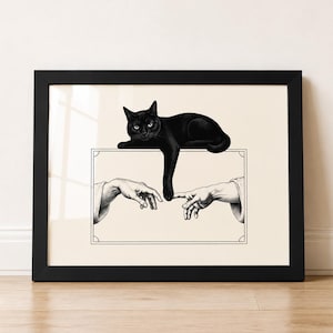 Könnte beinhalten: Ein gerahmter Kunstdruck mit einer schwarzen Katze, die auf einem rechteckigen Rahmen liegt. Innerhalb des Rahmens strecken sich zwei menschliche Hände einander entgegen, wobei die Pfote der Katze nach unten reicht, um einen Finger zu berühren.