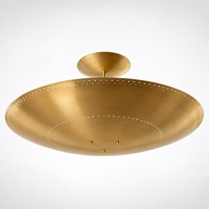 May include: A circular, brushed brass flush mount ceiling light fixture featuring a wide, shallow, bowl-shaped shade. The metal surface is accented with two concentric rings of small, evenly spaced perforations along the outer edge.