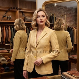 May include: A light yellow blazer with a textured snakeskin pattern, featuring a notched lapel, two yellow buttons, and two front patch pockets. The blazer is worn over black trousers, with the text Legacycraftedstore visible in the image.