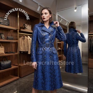 May include: A double-breasted trench coat in a vibrant blue snakeskin print featuring a notched collar, long sleeves with buckled cuffs, two front flap pockets, and a matching waist belt with a rectangular buckle. The text LEGACYCRAFTEDSTORE is visible.