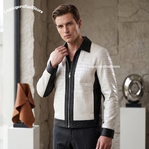 May include: A white and black jacket featuring a textured crocodile skin pattern on the white panels and a smooth black finish on the collar, front placket, sides, and cuffs. The jacket has a full-length silver zip closure and a standard collar.