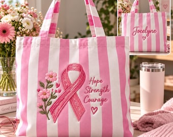 May include: A pink and white striped tote bag featuring an embroidered pink awareness ribbon, a floral stem, and the text Hope Strength Courage. The back of the bag displays the embroidered name Jocelyne above a small heart symbol.