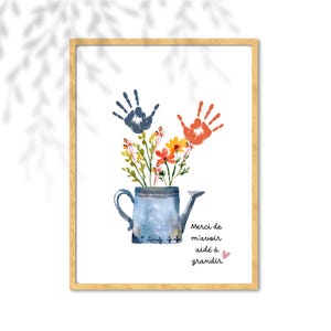 Puede incluir: Una lámina enmarcada con una regadera azul en acuarela, un ramo de flores coloridas y dos huellas de manos en azul y naranja encima. El texto dice Merci de m'avoir aidé à grandir con un pequeño corazón rosa junto a la última palabra.