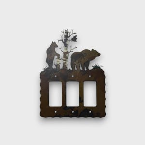 May include: A triple light switch cover plate made of dark brown metal with a rustic finish. The top section features a silhouette design of two bears standing near a central tree. The plate has three rectangular cutouts and six screw holes.