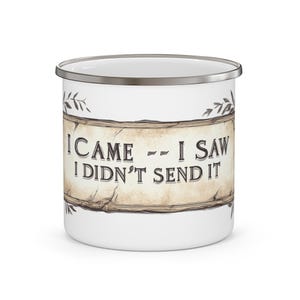 May include: A white enamel mug with a silver rim featuring a central graphic of a weathered parchment scroll. The text on the scroll reads I CAME -- I SAW I DIDN'T SEND IT in a dark serif font, accented by small botanical leaf illustrations.