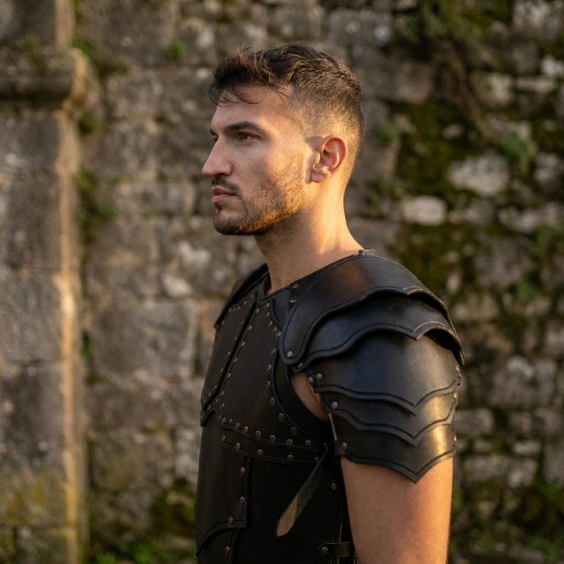 May include: A black leather chest and shoulder armor piece featuring layered pauldrons with scalloped edges. The armor is constructed with multiple panels secured by metal rivets and includes adjustable leather straps along the side for a secure fit.