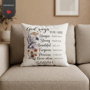 Può includere: Un cuscino quadrato bianco con un bouquet floreale sul lato sinistro e testo nero che recita: God says YOU ARE Unique PSALM 139:13, Strong PSALM 18:35, Beautiful ECCL. 3:11, Forgiven PSALM 103:12, Precious 11 COR. 6:20, Never alone MATTHEW 28:20 SARAH.